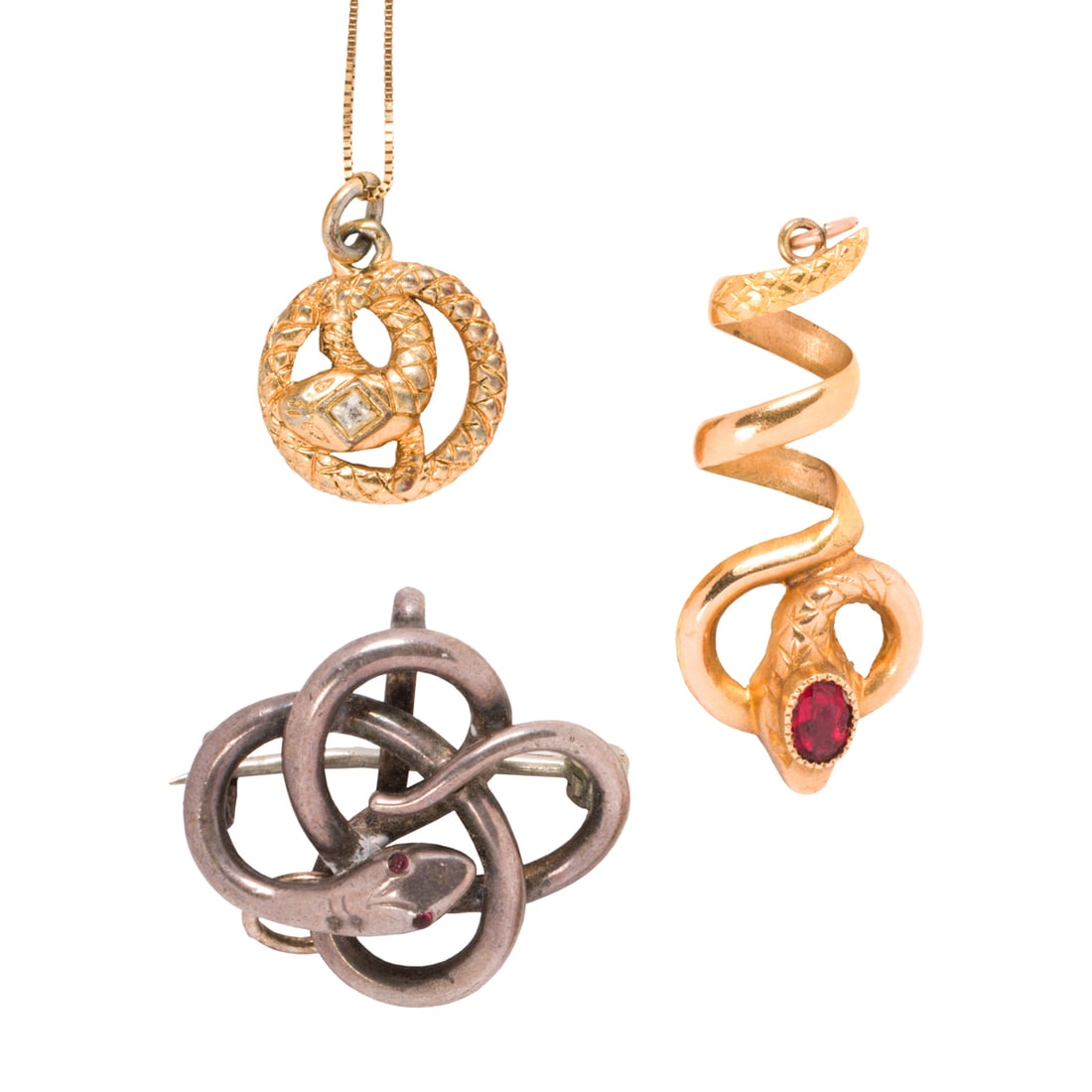 Three antique snake pendants and chain: Three antique snake pendants and chain Comprising one 18k gold snake pendant set with an oval-cut glass gemstone, one gold-filled snake pendant on 14k gold chain, and one silver snake pendant-brooch;