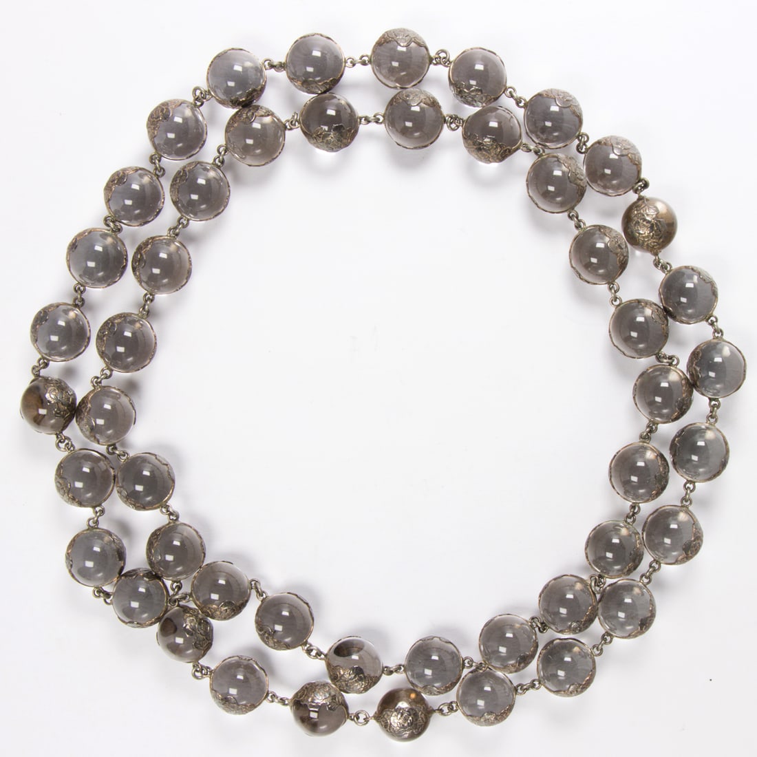 An Art Deco rock crystal and sterling silver "Pools of Light" necklace: An Art Deco rock crystal and sterling silver "Pools of Light" necklace Designed as un-drilled rock crystal spheres measuring 12.11 mm, joined by sterling silver findings etched with floral motifs; len