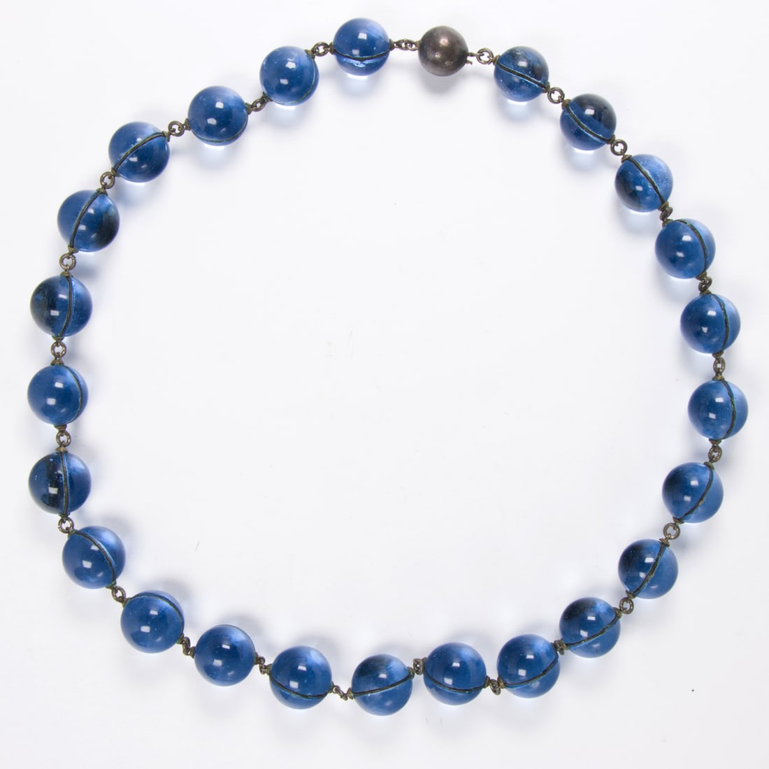 An antique glass and sterling silver necklace: An antique glass and sterling silver necklace Designed with un-drilled spherical blue glass beads joined by sterling silver; length: 18 1/3 in; 73.50 grams