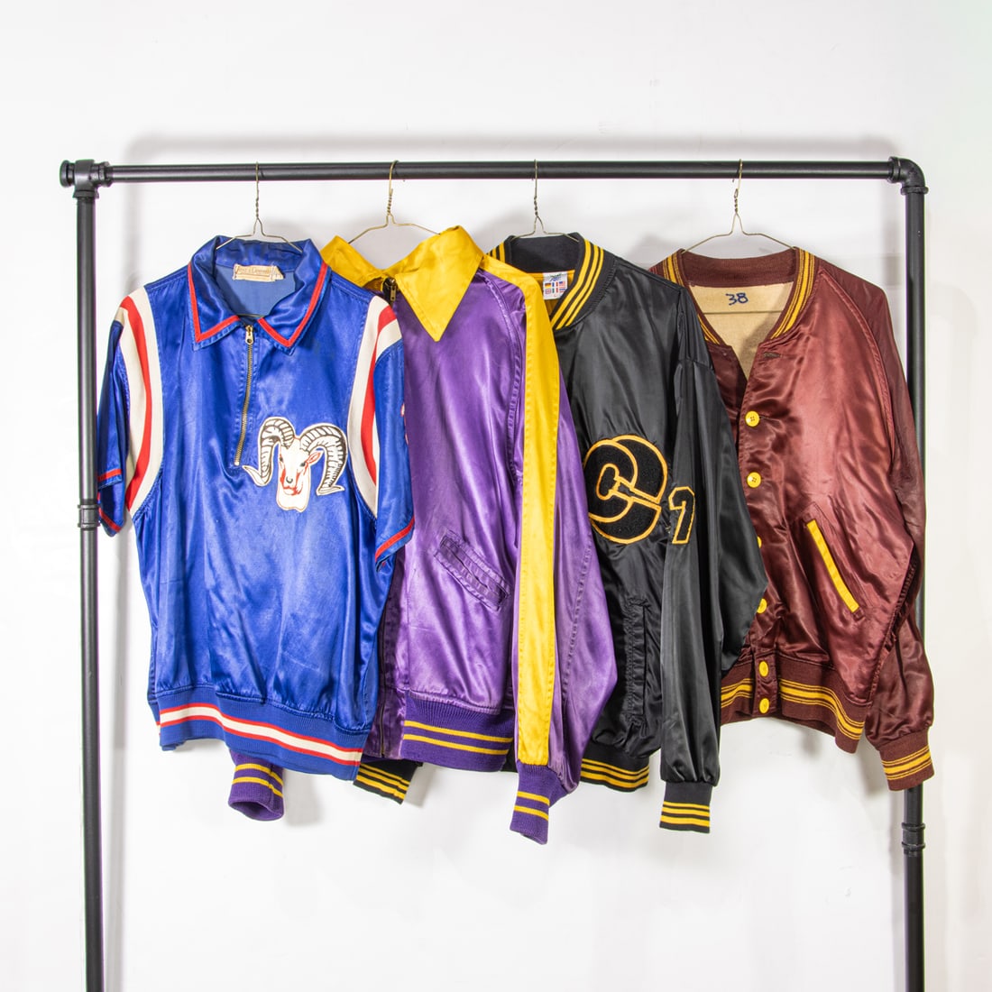 Three vintage satin jackets and one satin jersey: Three vintage satin jackets and one satin jersey, (1) royal blue "Ladue" jersey size 44, (1) purple and golden yellow "Condos D.C.J.C." size not labeled , (1) black and golden yellow "International
