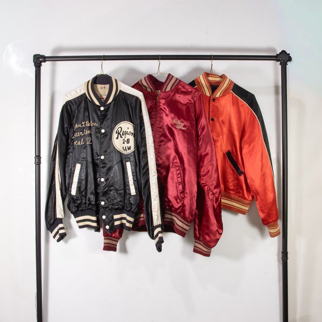 Three vintage satin jackets: Three vintage satin jackets, (1) black and white "Region 2-B UWA" size 44, (1) black and red "FT Morgan Fire Department" size not given, (1) red "Rolling Stones Rock N Roll" size large