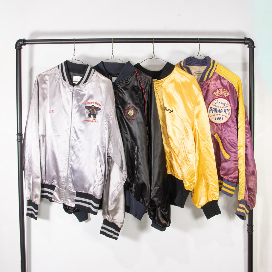 Four vintage satin jackets: Four vintage satin jackets, (1) silver "Empy's Gym" size large, (1) black "Bally's Casino Resort" size xlarge, (1) golden yellow "Rocky III" size not labeled, (1) maroon and yellow "Parma Slow Pitch