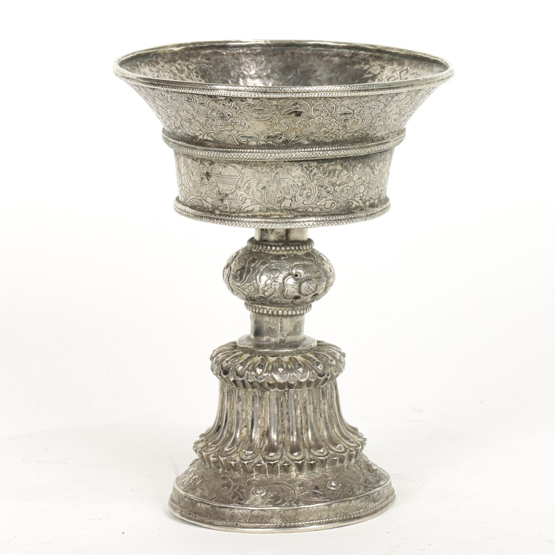 A Tibetan silver butter lamp: A Tibetan silver butter lamp. Incised decorated with the auspicious emblems, 20th century, 5" high and 186 grams.