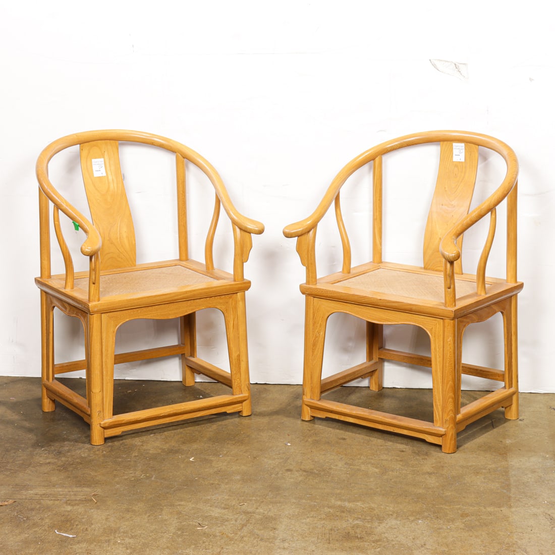 A pair of Chinese elm horse-shoe back armchairs for children: A pair of Chinese elm horse-shoe back armchairs for children. 20th century, 27"h x 17"w x 13"d.