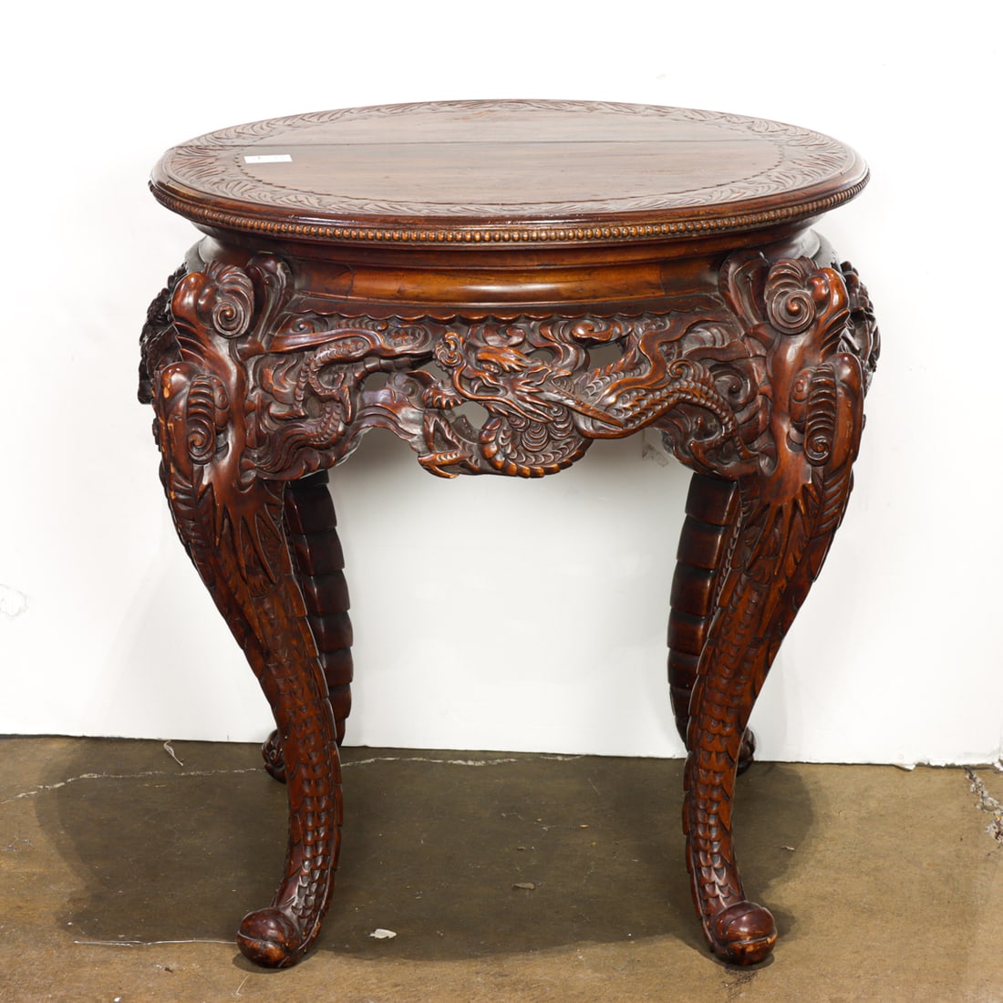 A Japanese carved wood circular 'dragon' table: A Japanese carved wood circular 'dragon' table. Early 20th century, 29.5"h x 36"w.