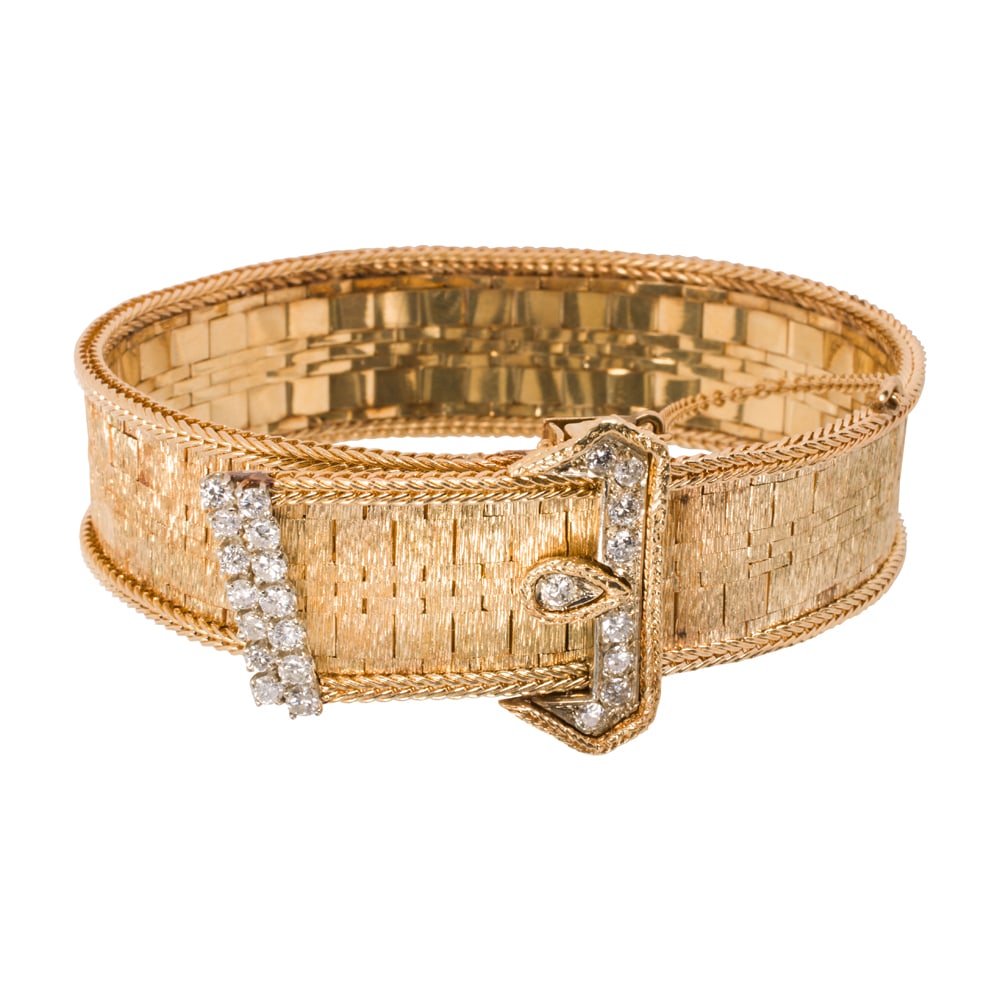 A retro diamond and 18k gold buckle bracelet: A retro diamond and 18k gold buckle bracelet the textured strap bracelet with buckle design clasp set with 23 round brilliant-cut diamonds, weighing in total an estimated 1.10 carats; length: 7 - 7