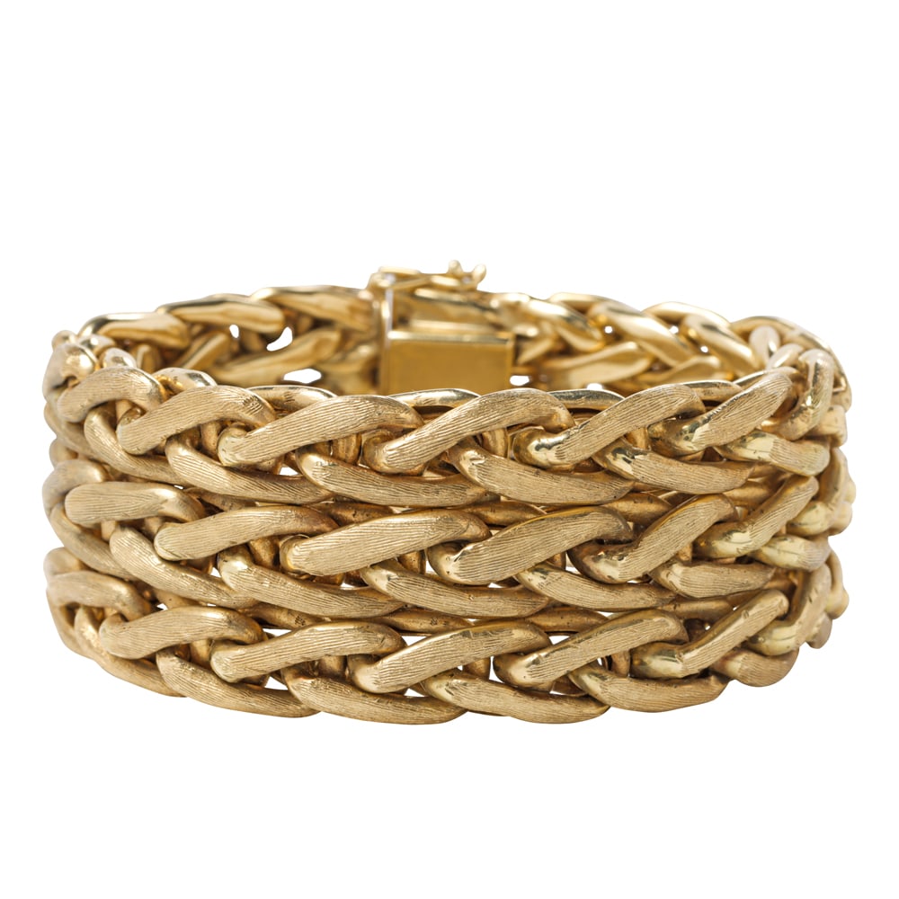 A 14k gold bracelet: A 14k gold bracelet The flexible strap of knit weave with florentine finish; length: 7 3/8 in; width: 1 in; 99.25 grams