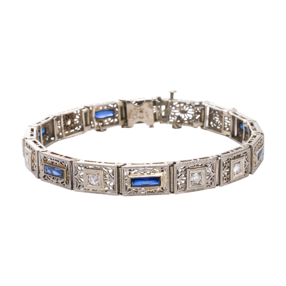 An Art Deco synthetic sapphire, diamond, and platinum topped 14k white gold bracelet: An Art Deco synthetic sapphire, diamond, and platinum topped 14k white gold bracelet Of open-form filigree design, set with six baguette-cut synthetic sapphires and seven transitional-cut diamonds;