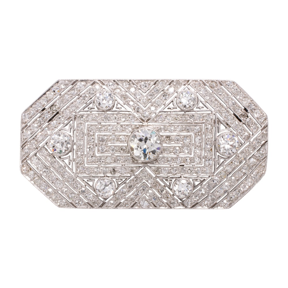 A diamond and platinum brooch: A diamond and platinum brooch the deco style octagonal brooch featuring seven collect-set European-cut diamonds, together weighing approximately 1.50 carats, further set throughout with numerous