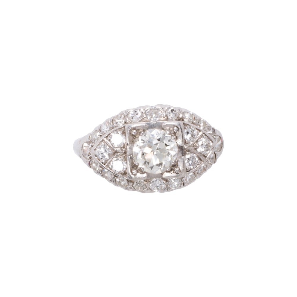 An diamond and platinum ring: An diamond and platinum ring Circa 1930-40, centering a transitional-cut diamond weighing approximately 0.55 carat, framed by 26 transitional and single-cut diamonds; estimated total diamond weight: