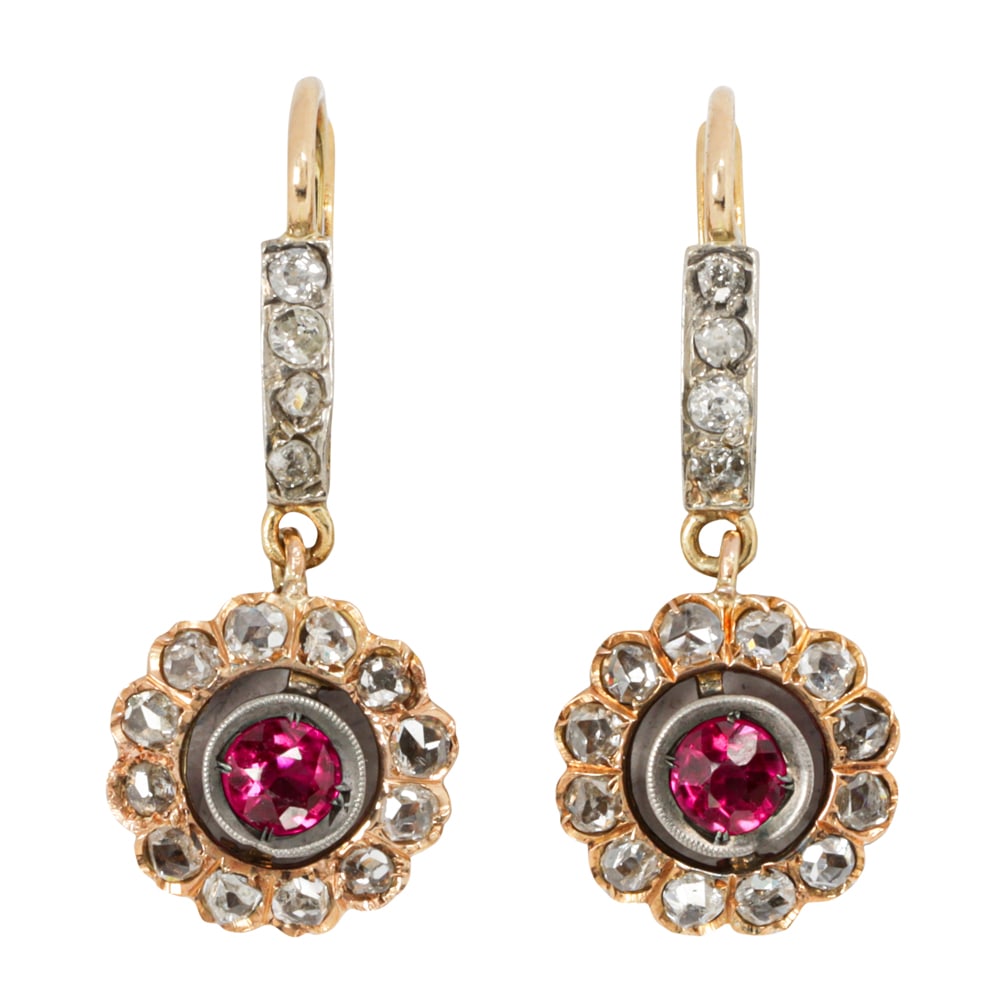 A pair of antique ruby, diamond and 18k bi-color gold earrings: A pair of antique ruby, diamond and 18k bi-color gold earrings each earring drop centering a round-cut ruby within a rose-cut diamond halo, with diamond-set Euro-lever backs; estimated total ruby weig