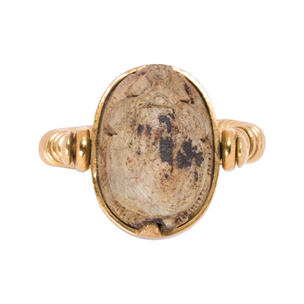 A 20k gold Egyptian revival scarab ring: A 20k gold Egyptian revival scarab ring Featuring a carved hardstone scarab measuring 19.38 x 13.20 mm, within modernist 20k gold shank; size 7; 16.85 grams