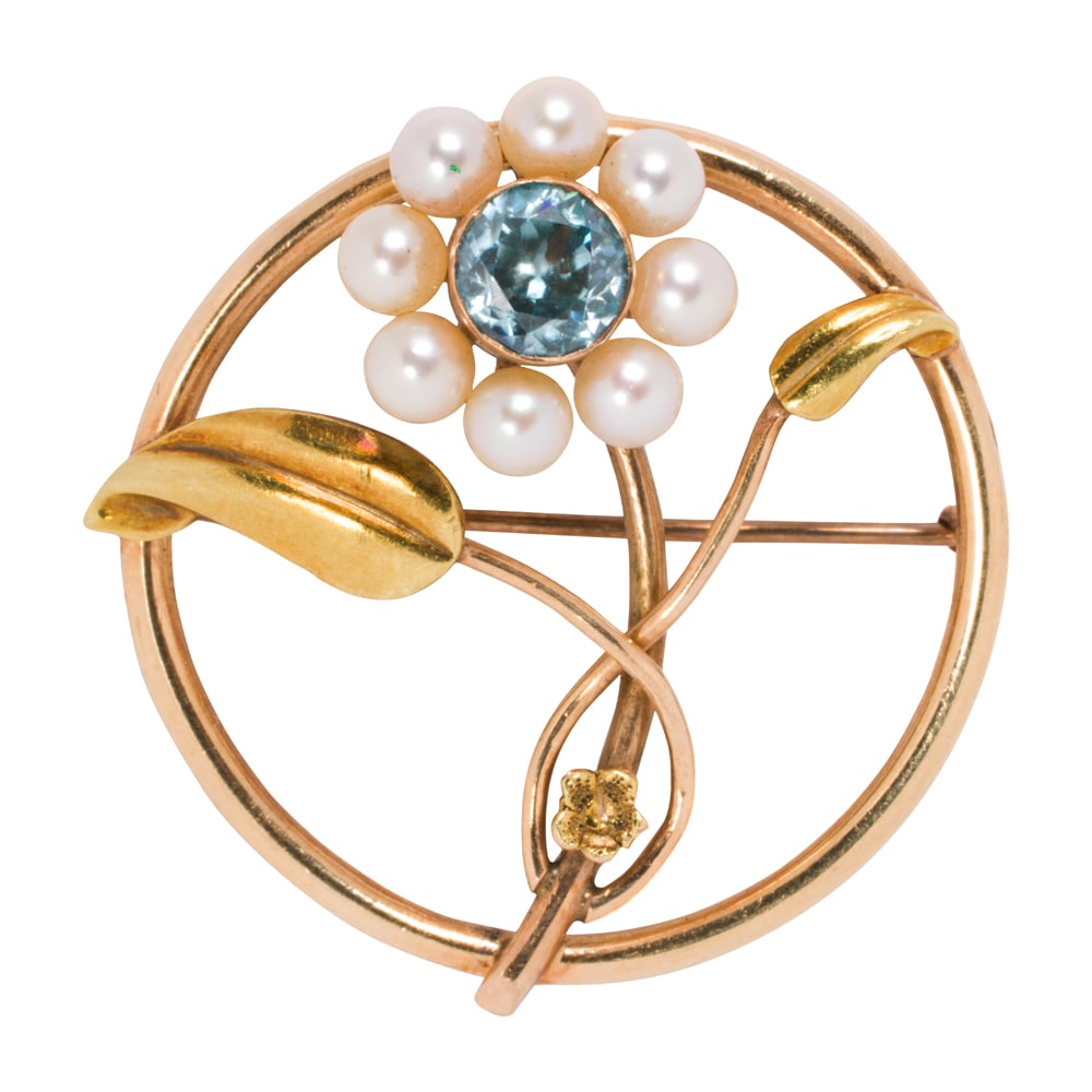 A blue zircon, cultured pearl, and 10k gold brooch: A blue zircon, cultured pearl, and 10k gold brooch Designed as a flower within a circular frame, set with a round-cut blue zircon measuring 5.96 mm across, framed by four cultured pearls measuring