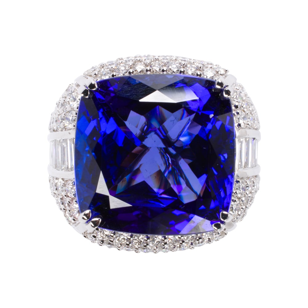 A tanzanite, diamond, and 14k gold ring: A tanzanite, diamond, and 14k gold ring Featuring a cushion-cut tanzanite weighing 23.52 carats, accented by round brilliant and baguette-cut diamonds; total diamond weight: 4.21 carats; size 7;