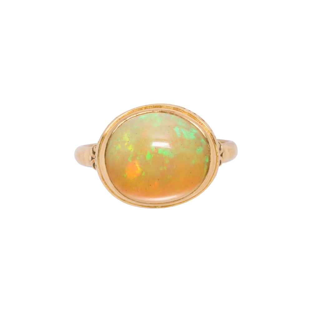 A vintage opal and 18k gold ring: A vintage opal and 18k gold ring Featuring an oval shaped opal cabochon measuring 11.60 x 10.12 x 5.42 mm, set within decorative etched bezel; size 6 1/2; 3.20 grams