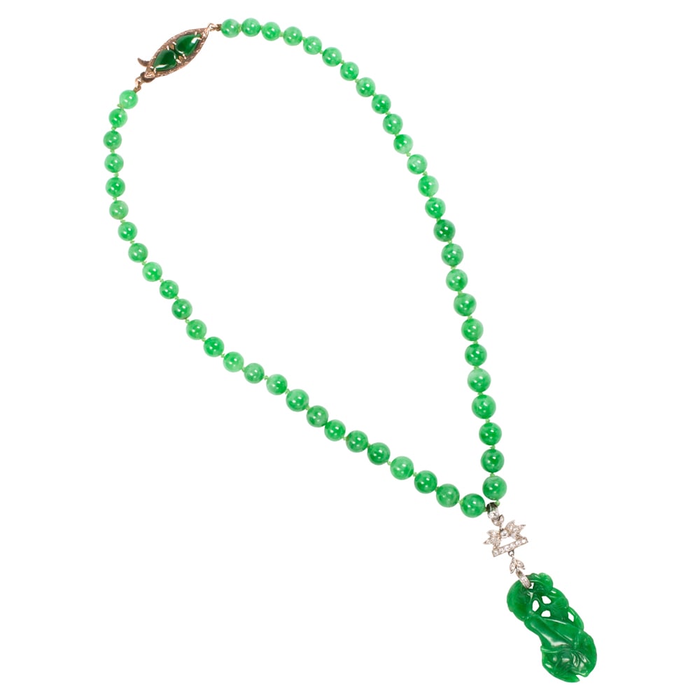 A jade, diamond, platinum and 14k gold pendant necklace: A jade, diamond, platinum and 14k gold pendant necklace composed of 50 round jade beads measuring from 5.60 to 7.10 mm, suspending an art deco pendant featuring a carved jade of gourd, foliate and ins