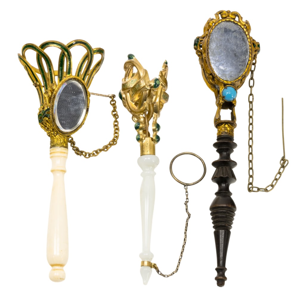 Three English or French gilt metal posy holders or tussie mussies: Three English or French gilt metal posy holders or tussie mussies, circa 1870, the first French with opaline glass handle; the second English green enamel decorated with flirting mirror; the third