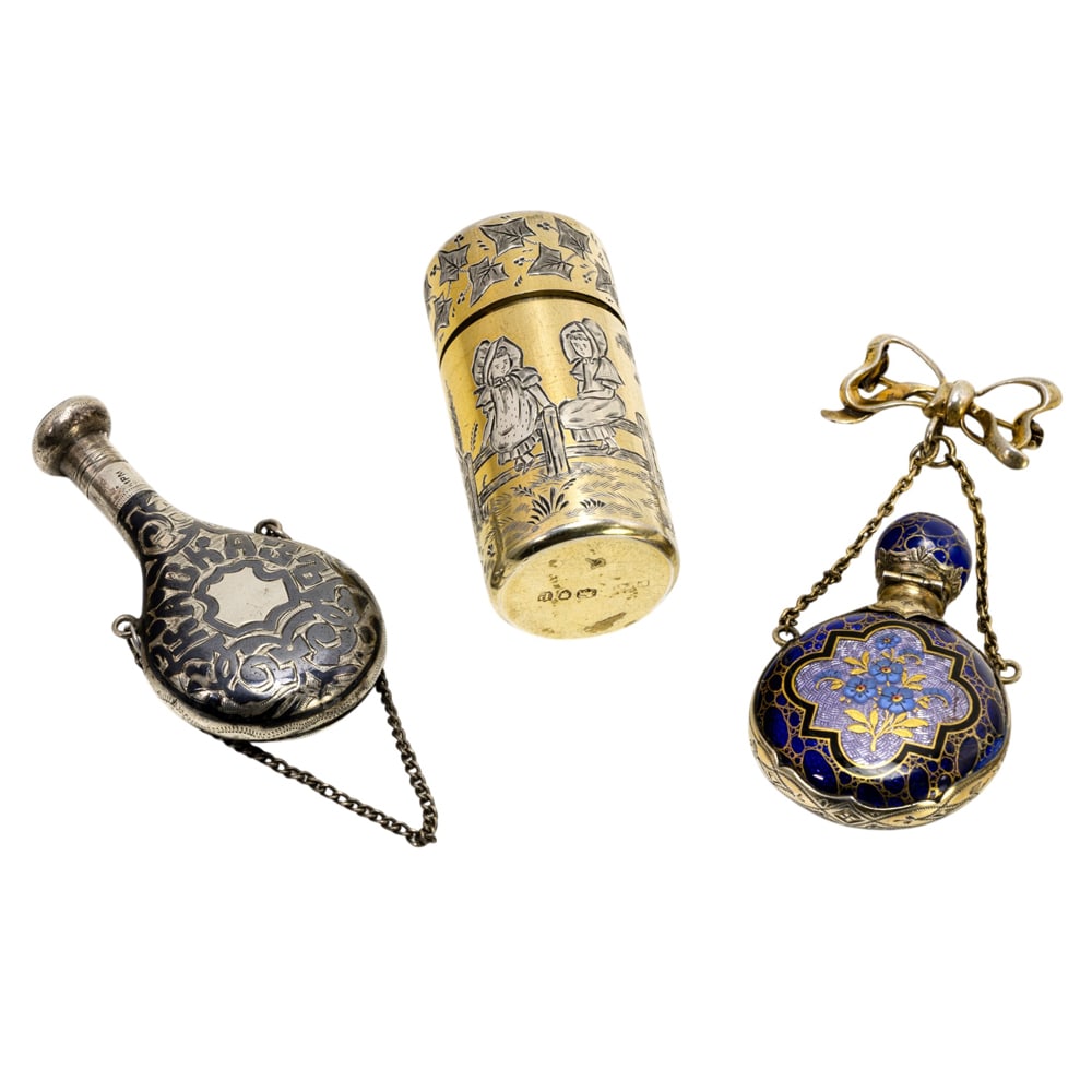 Three silver scent bottles: Three silver scent bottles, late 19th century, the first guilloche enamel suspended from tied ribbon pin, indistinctly stamped ?..lver?; the second Russian 84 standard silver niello decorated scent fl