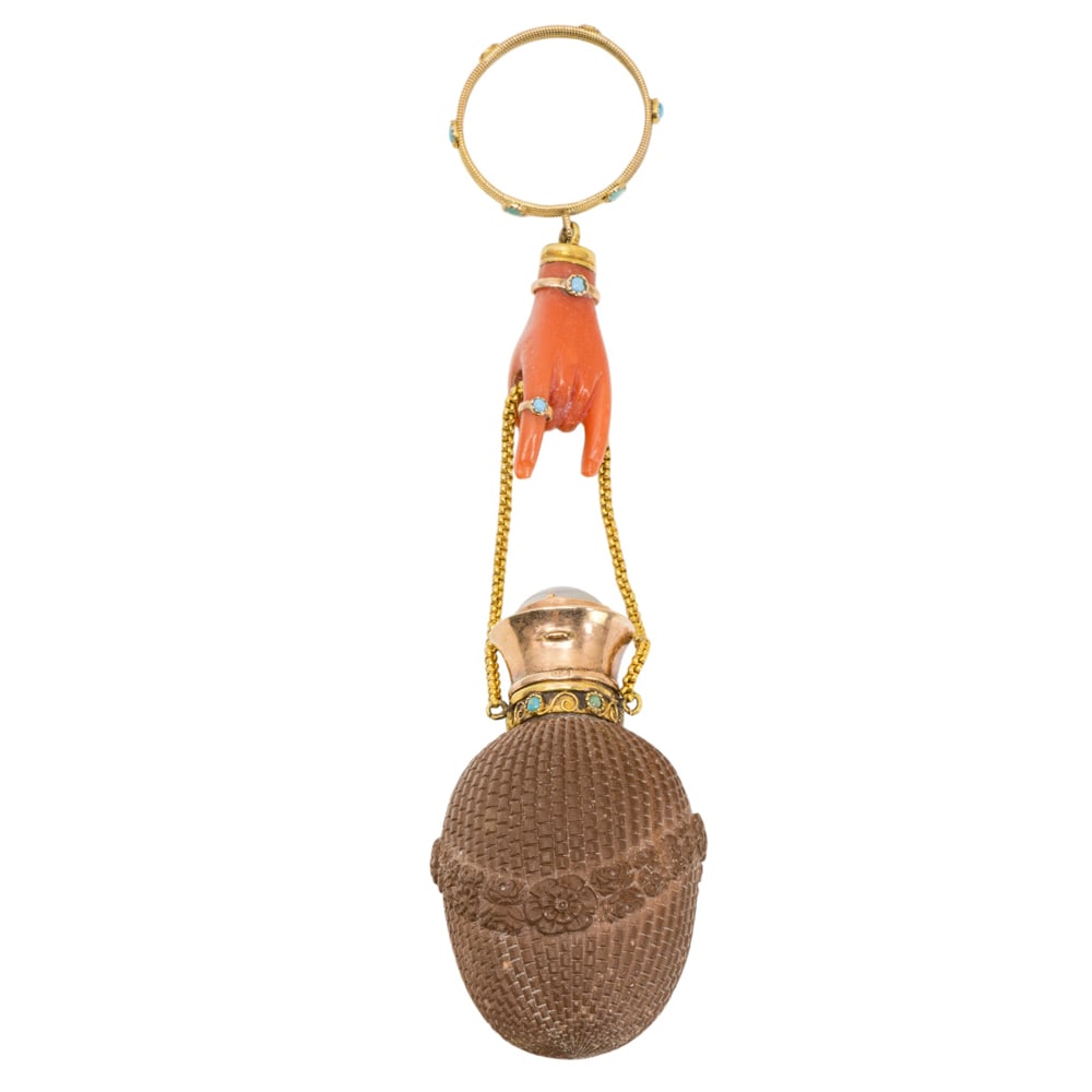 A French gold, coral, and turquoise mounted lava stone scent flask: A French gold, coral, and turquoise mounted lava stone scent flask, circa 1860, modeled as a hand holding a basket form bottle from a chain, fitted with ring, indistinctly marked, 1.75"l (flask).