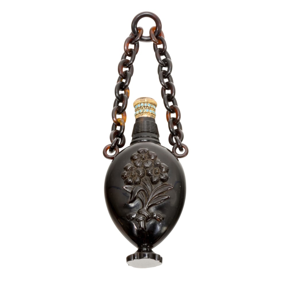 An English pressed scent bottle with 18k gold and turquoise cap: An English pressed scent bottle with 18k gold and turquoise cap, mid-19th century, the ovoid bottle decorated with flowers suspended from a chain, 3.25?l. Provenance: The Collection of Irene Deitsch,