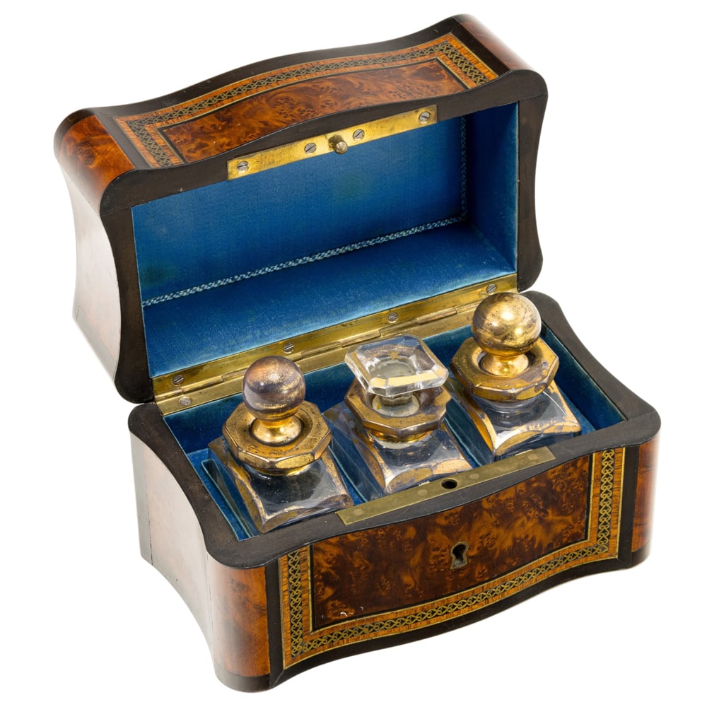 A Napoleon III brass inlaid burlwood scent box: A Napoleon III brass inlaid burlwood scent box, third quarter 19th century, the cover inscribed ?Marguarite?, the interior fitted with three gilt decorated glass bottles, case 4?h x 5.75?w x 3.5?d.