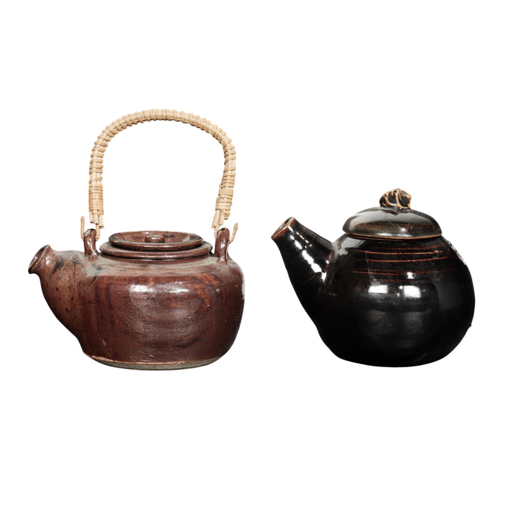 Ceramic Teapots, Jacomena Maybeck: (lot of 2) Jacomena Maybeck (American/Dutch, 1901-1996), Teapots, ceramic teapots with lids, one with rattan handle, each signed beneath, overall (for larger): 5"h x 6"w x 4.75"d. Provenance: