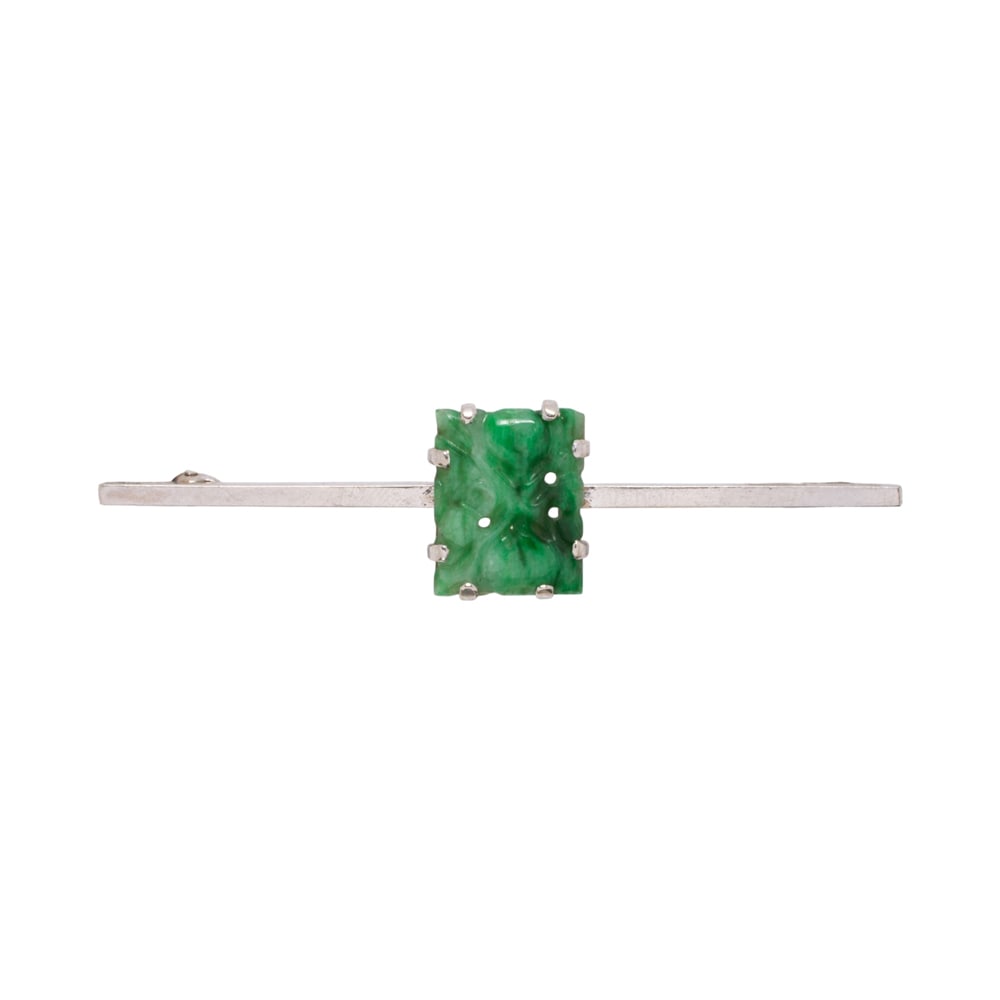 A jade pin: A jade pin The bar pin set with a carved jade tablet measuring 13.40 x 10.49 mm; length: 12 1/4 in; 4.60 grams