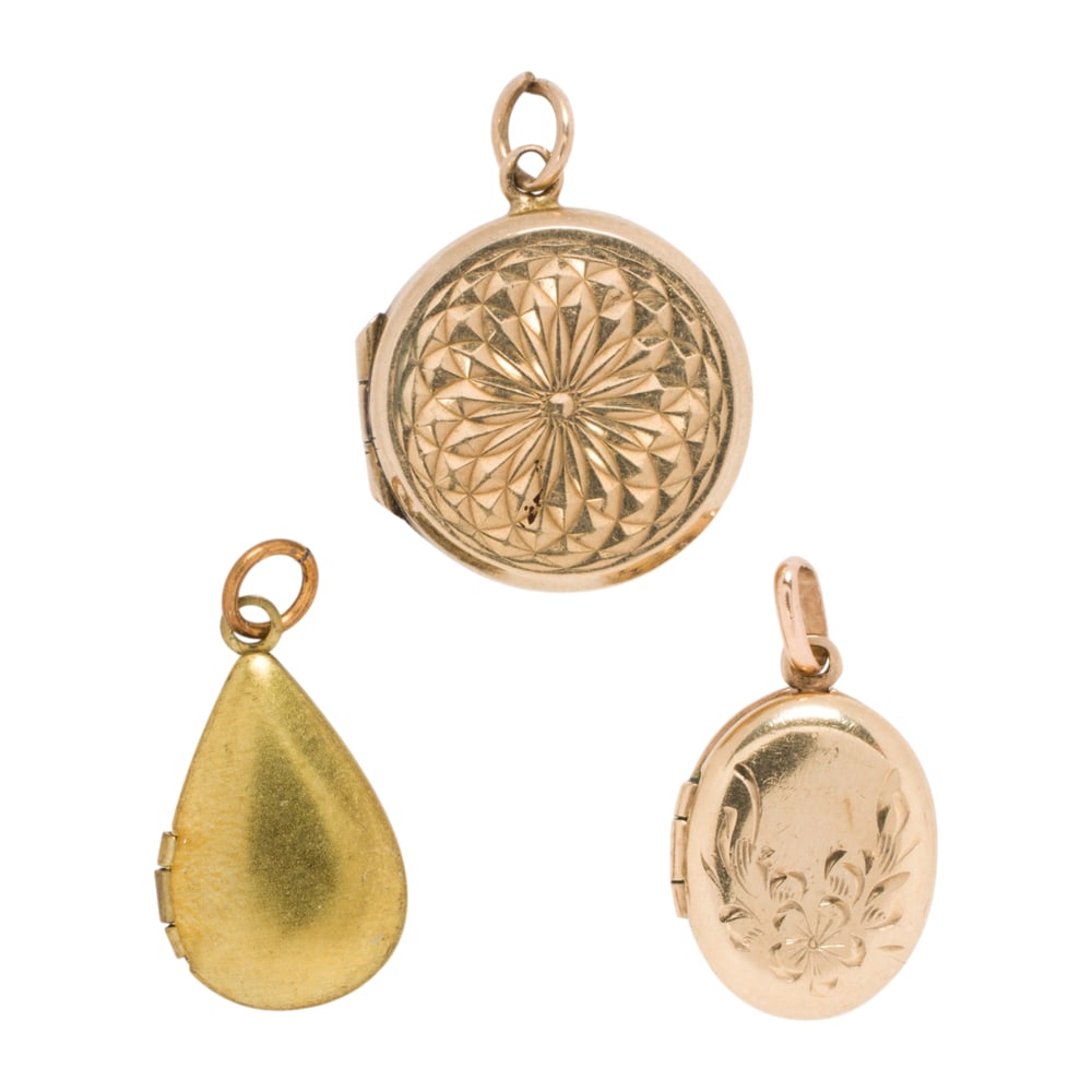 Three antique gold and gold-filled lockets: Three antique gold and gold-filled lockets Comprising one 10k gold, one 9k gold, and one gold-filled locket of varying styles; gross weight: 4.65 grams