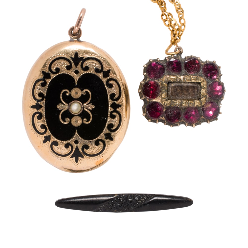 Three pieces of gold and gold-filled Victorian mourning jewelry: Three pieces of gold and gold-filled Victorian mourning jewelry Featuring one enamel and 10k gold locket and two gold-filled pins of varying styles and designs; gross weight: 9.15 grams