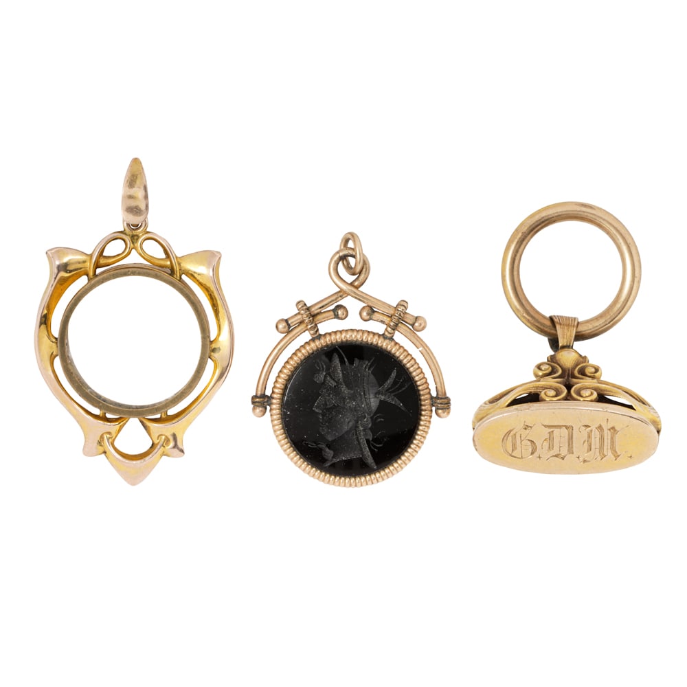 Three antique gold-filled watch fobs: Three antique gold-filled watch fobs The fobs of varying styles and designs; gross weight: 14.00 grams