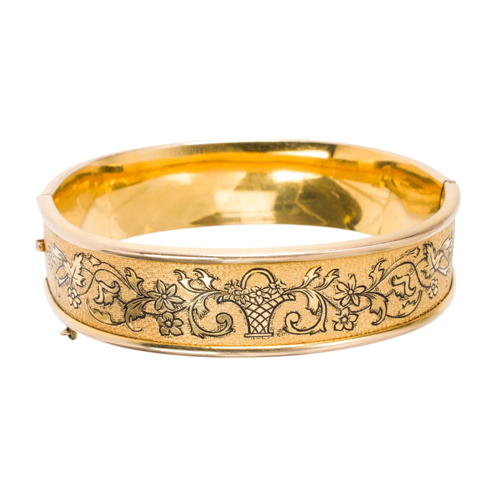 A gold-filled bangle bracelet: A gold-filled bangle bracelet The bracelet featuring etched floral accents; interior width: 2 1/2 in; 28.70 grams