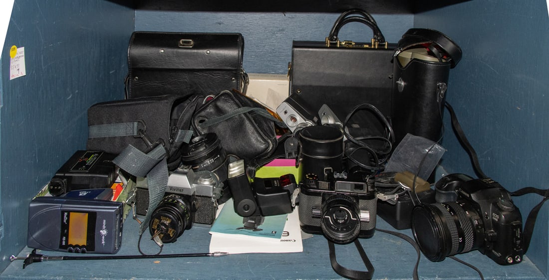 An assembled group of cameras and equipment: An assembled group of cameras and equipment, including Vivitar 220/SL; Tamron Promaster lens; vintage GAF SS 805 Super 8 movie camera with Chinon Reflex lens; Nikonos-III camera; Canan EOS D60 DSLR ca