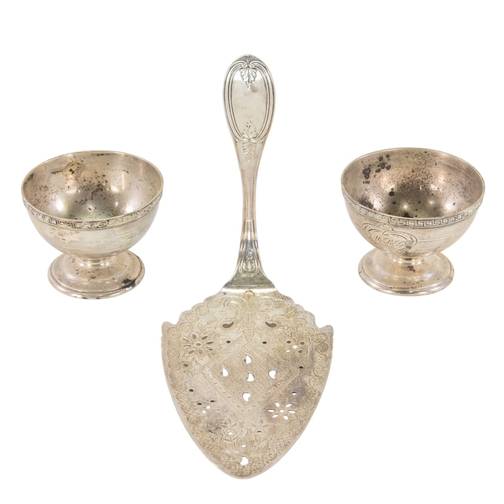 A coin silver pierced and engraved flat server: A coin silver pierced and engraved flat server, Crosby, Hunnewell & Morse, Boston, circa 1861-1864, Olive pattern monogrammed on verso, L. 10 1/2 in; together with a pair of coin silver footed salt