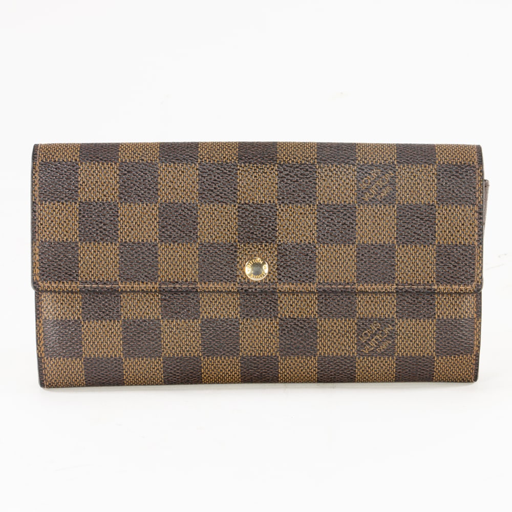 A Louis Vuitton Damier Ebene canvas long wallet: A Louis Vuitton Damier Ebene canvas long wallet, featuring leather lining, gold toned hardware and flap closure, 4"h x 7.5"l