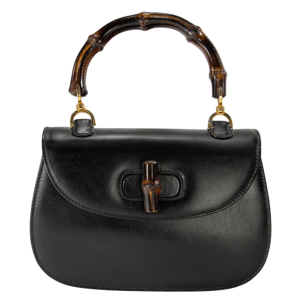 A vintage Gucci black leather and bamboo 1947 top handle handbag: A vintage Gucci black leather and bamboo 1947 top handle handbag, featuring gold tone hardware, turn-lock closure and leather lining, marked in gold foil 'Made in Italy by Gucci', 7.25"h x 10.25"w x 3