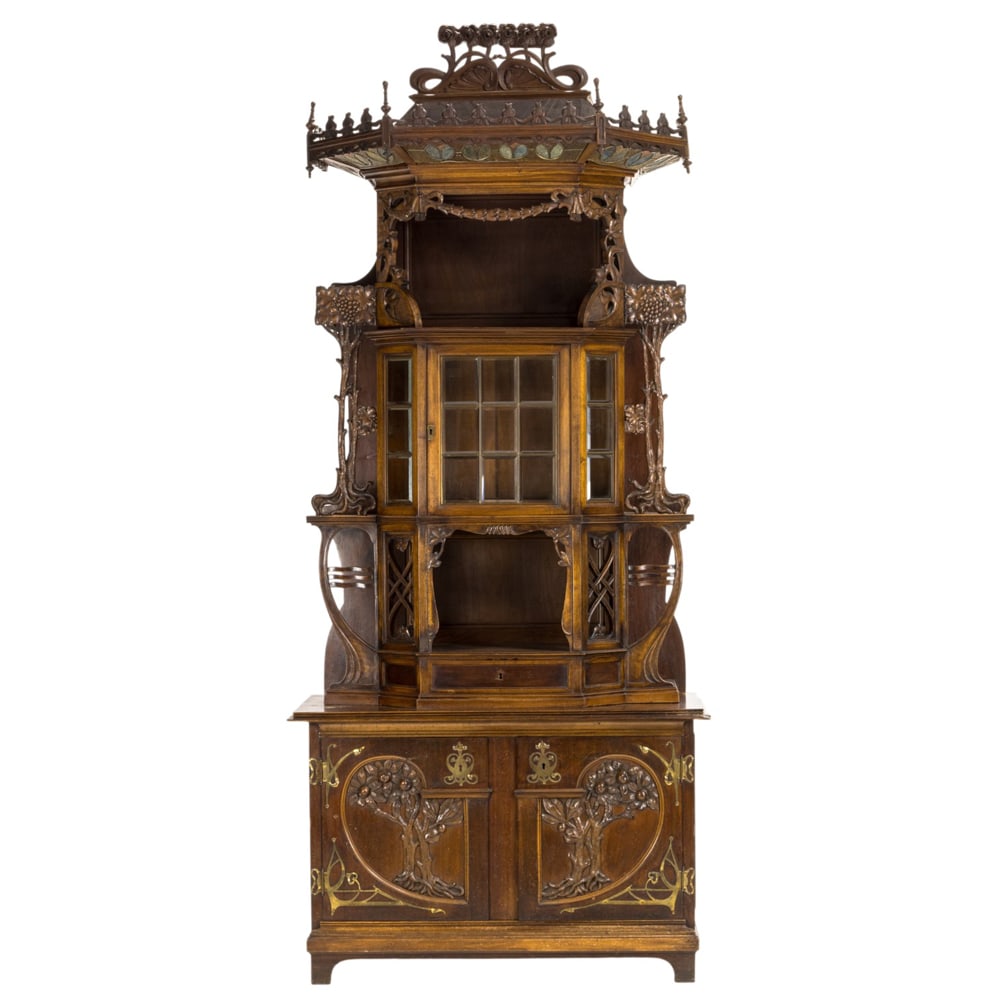 A fine Art Nouveau hand carved cabinet or etagere circa 1900: A fine Art Nouveau hand carved cabinet or etagere circa 1900, the highly carved case with repeating floral reserves surmounting the leaded glass panels above the tiered case, the sides with stylized c