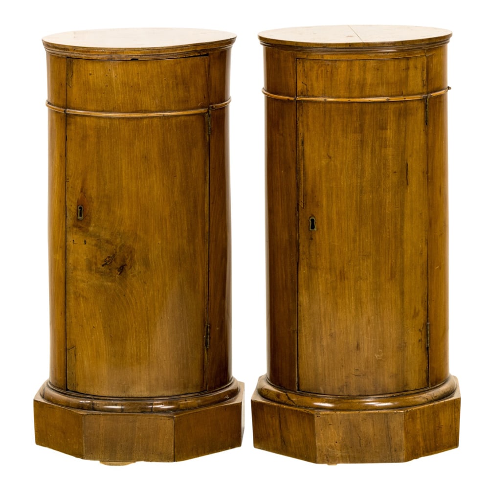 A pair of Biedermeier pedestal cabinets: A pair of Biedermeier pedestal cabinets, 19th century, each of drum form with single door opening to single drawer and shelf, 30"h x 14"dia x 15"sq (base)