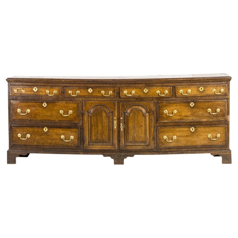 A George II oak chest 18th century: A George II oak chest 18th century, the long form with paneled doors and banded drawer fronts, with replaced hardware and rising on a molded base, 33"h x 85"w x 19"d