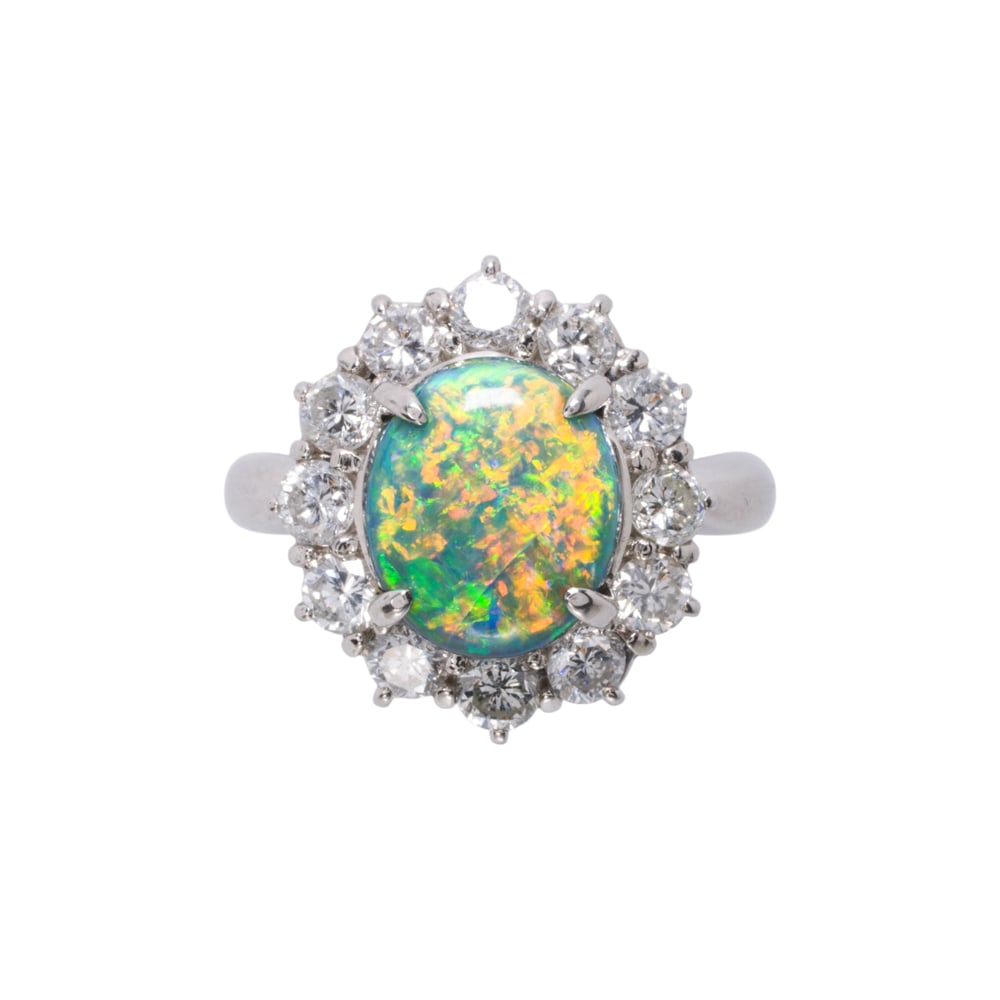 An opal, diamond and platinum ring: An opal, diamond and platinum ring centering an oval back opal cabochon measuring approximately 9.83 x 8.30 x 4.32 mm, framed by round brilliant-cut diamonds; estimated total diamond weight: 1.08 cara