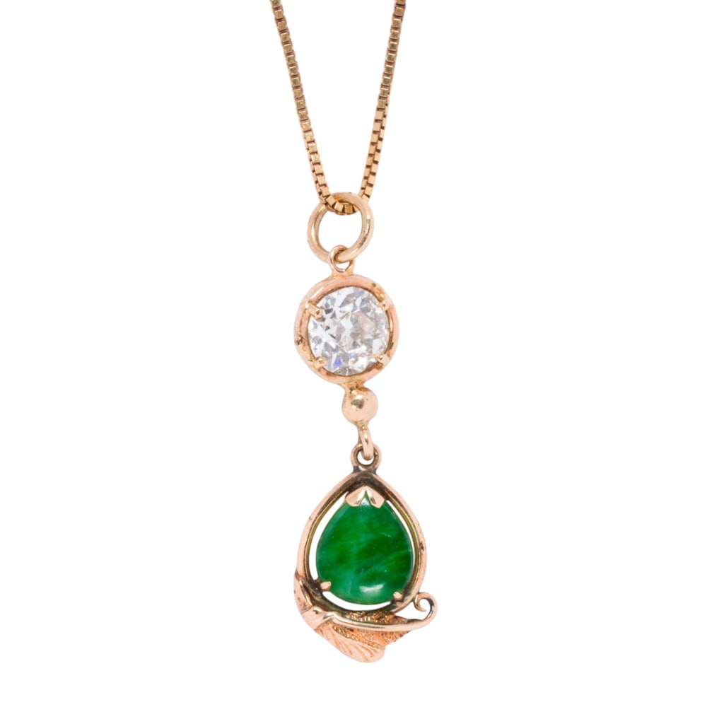 A diamond, jade, and 10k gold pendant necklace: A diamond, jade, and 10k gold pendant necklace The pendant featuring an old European-cut diamond weighing approximately 1.25 carats, surmounting a foliate accent set with a pear-shaped jade cabochon m