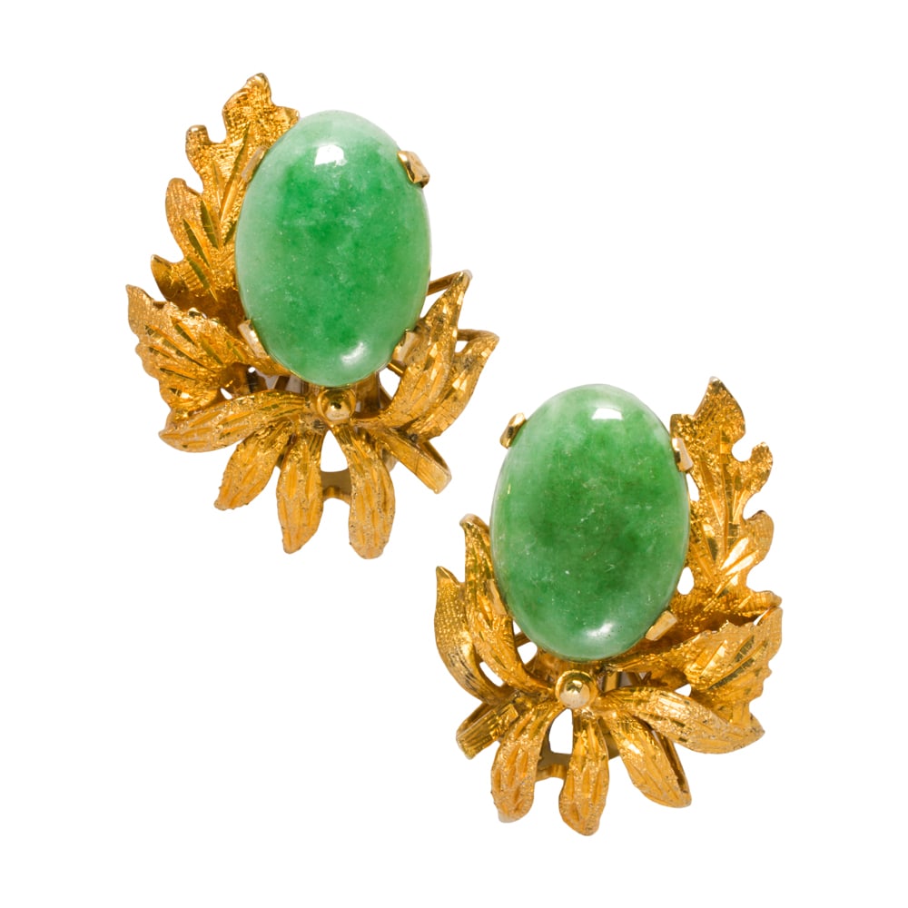 A pair of jade and 18k gold ear-clips: A pair of jade and 18k gold ear-clips Centering oval-shaped jade cabochons measuring 14.10 x 10.14 mm, within foliate 18k gold mounting; length: 1 in; 9.30 grams