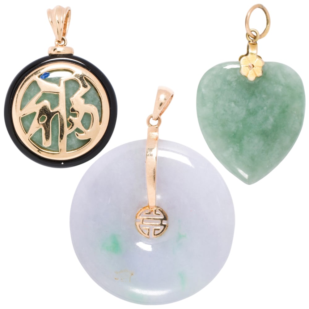 Three jade and 14k gold pendants: Three jade and 14k gold pendants Comprising three jade pendants of varying designs, set within 14k gold; gross weight: 26.65 grams