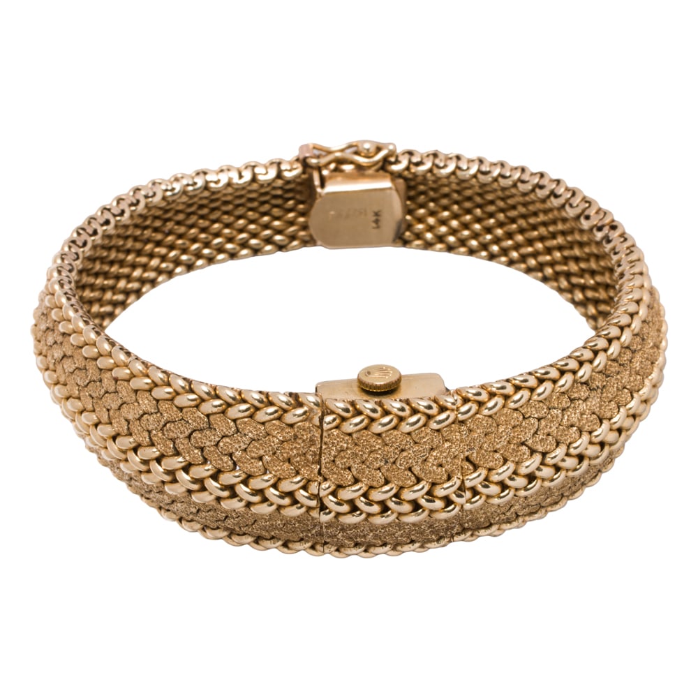A Rolex 14k gold hidden watch bracelet: A Rolex 14k gold hidden watch bracelet designed as a textured gold strap containing a Montres Rolex S.A 17 jewel unadjusted movement; length 7 in; 51.40 gram