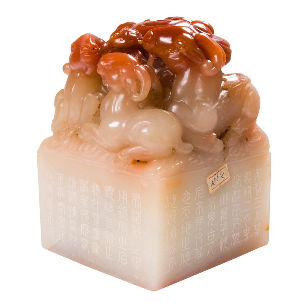 A Chinese soapstone 'three rams' seal: A Chinese soapstone 'three rams' seal. Of rectangular form, the top carved in relief with a large lingzhi surrounded by rams, the sides incised with inscription, 6.25" high.