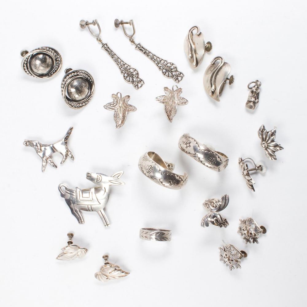 A group of silver jewelry: A group of silver jewelry comprising 7 pairs of earclips, 2 brooches (one signed TAXCO MN) two ring and a pendant; 60.00 grams gross