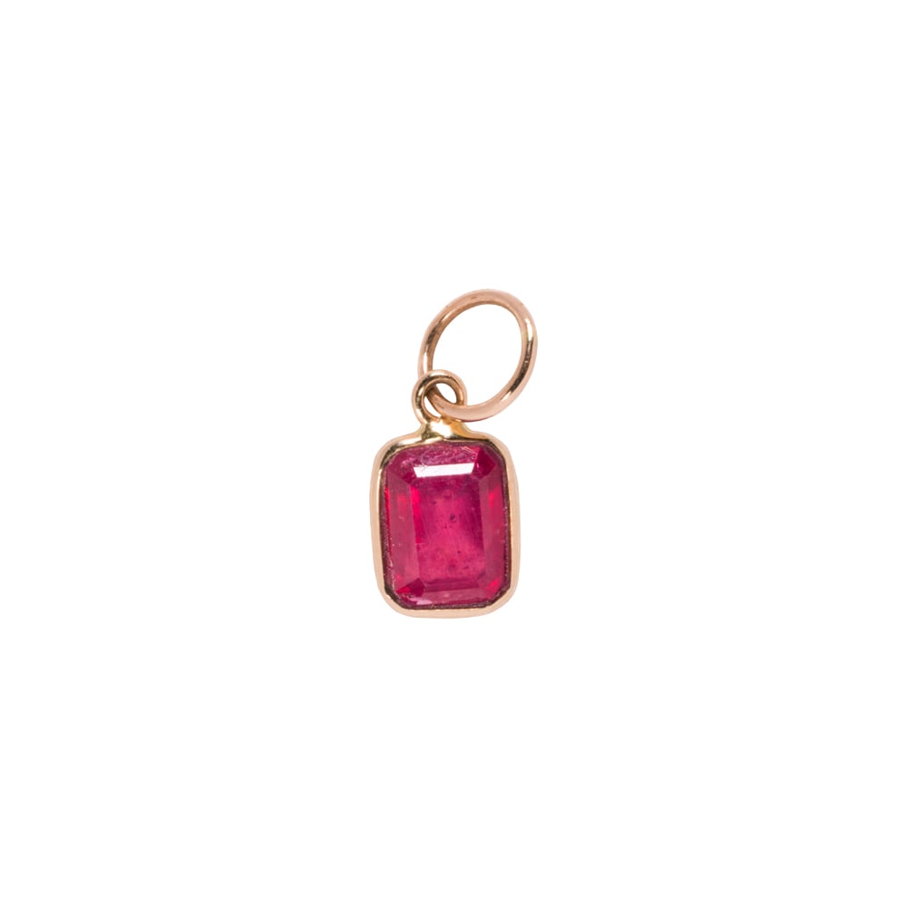 A glass-filled ruby and 14k gold charm: A glass-filled ruby and 14k gold charm Featuring an emerald-cut, glass filled ruby within 14k gold bezel; length: 1/2 in; 0.40 grams