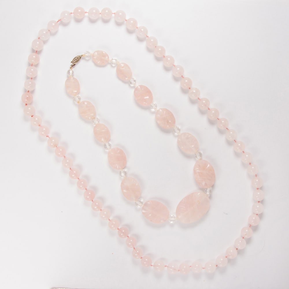 A group of rose quartz jewelry: A group of rose quartz jewelry including a strand of carved rosed quartz bead necklace, measuring approximately 15.90 -32.10 mm in length, accented by colorless quartz beads; a strand of fifty-six
