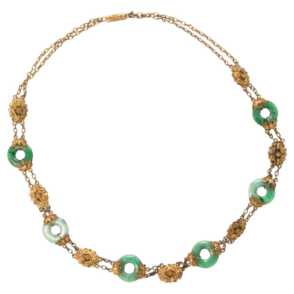 A jade and gold-washed silver necklace: A jade and gold-washed silver necklace Of intricate filigree design, featuring six jade rings; length: 20 1/2 in; 24.35 grams