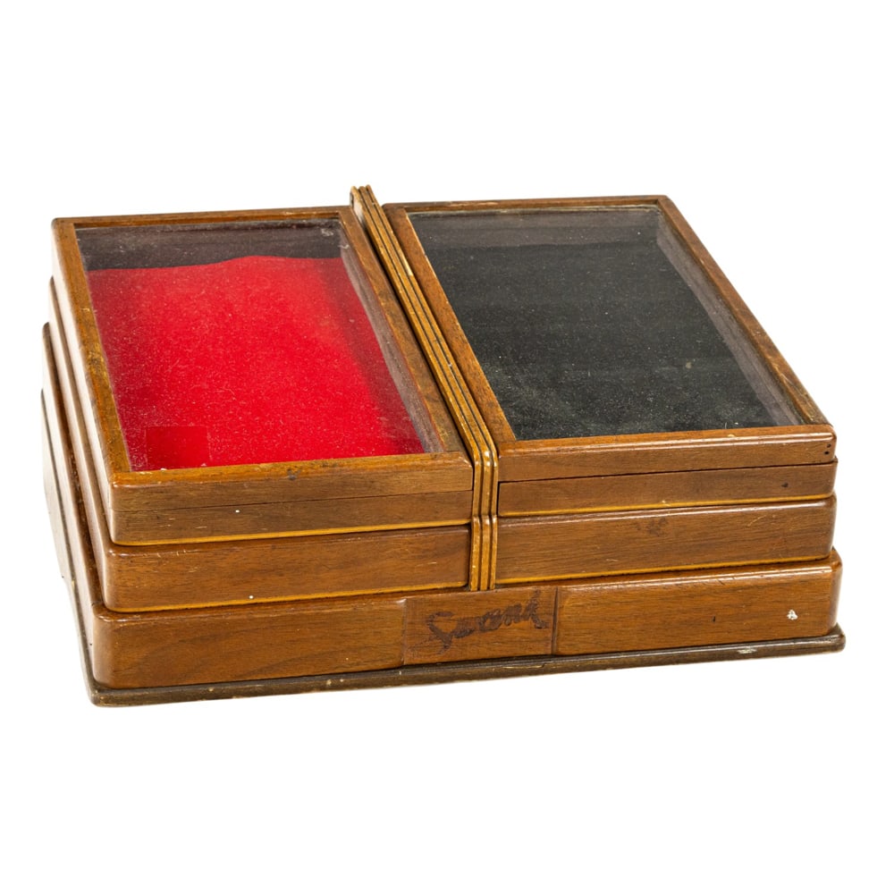 A vintage American glazed wood jewelry display case: A vintage American glazed wood jewelry display case, featuring a three level swing out tray mechanism over a rear compartment drawer, marked 'Swank', 7.5"h x 15.5"w x 14.5"d