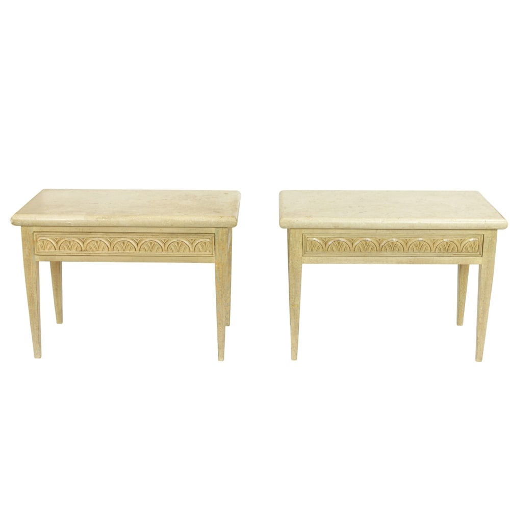A pair of custom side tables: A pair of custom side tables, each with a honed stone top above the light wash finished base with a carved frieze, and rising on tapered legs, 27"h x 39"w x 21"d